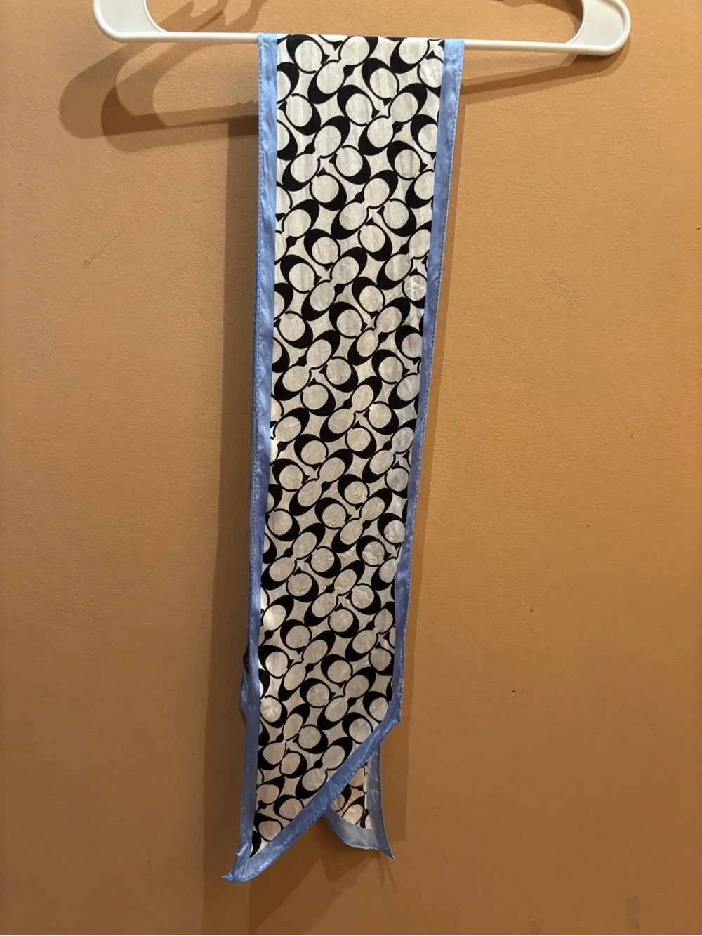 Coach scarf features the signature monogram print in black and white with light